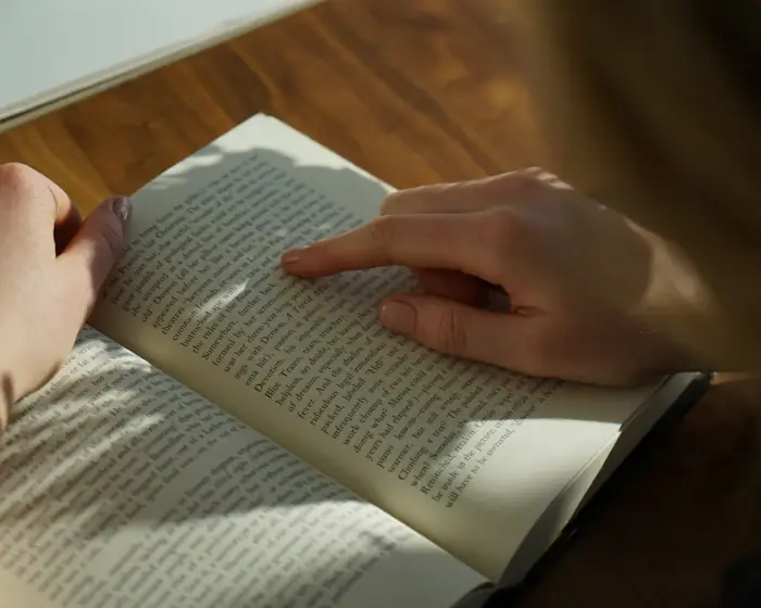 Hands resting on the pages of an open book