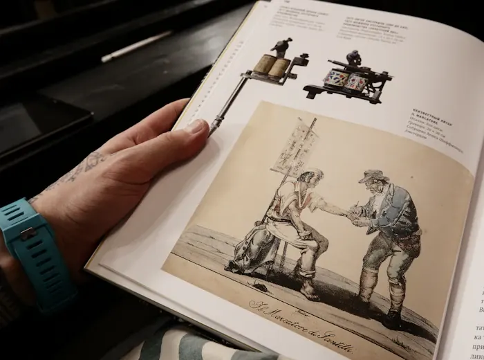 A reader holding an illustrated book open
